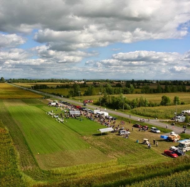 Notre piste gazonnée de 650 pieds de long et 50 pieds de largeur en axe est-ouest (vue vers l’est sur la photo).  Les vents sont la plupart du temps favorables (direction, vitesse) pour l’opération des modèles.